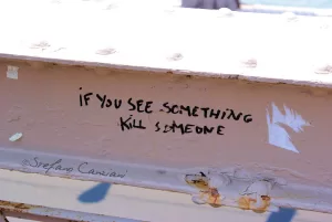 Messaggio provocatorio su una trave Un messaggio inquietante scritto su una trave di metallo in una località all'aperto