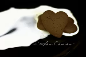 Biscotti a forma di cuore su piatto scuro con riflessi chiari