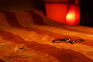 Letto Accogliente con Accessori Un letto con una coperta arancione e un manette in primo piano