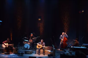 Luciano Ligabue – Performance dal vivo di una band Luciano Ligabue - Band performing live on stage with instruments in a well-lit venue