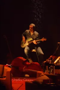 Luciano Ligabue – Musicista al Concerto Luciano Ligabue - Musicista su palcoscenico che suona il basso in un ambiente suggestivo