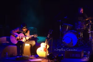 Luciano Ligabue – Performance dal Vivo di un Duo Musicale Luciano Ligabue - Un duo musicale sul palco, un chitarrista e un batterista, con luci soffuse