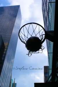 Un canestro da basket silhouettato contro il cielo in una zona urbana moderna