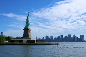 Statua della Libertà su Isola della Libertà con skyline di New York sullo sfondo