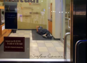 Silenzio Automatico Un corpo disteso sul pavimento di una banca automatizzata, dove la sicurezza è affidata alle macchine e l’umanità sembra sospesa.