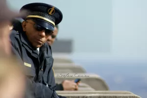 Poliziotto in servizio Uomo in uniforme di polizia con occhiali da sole osserva attentamente l'ambiente circostante