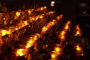 Candele Accese in un Luogo Sacro Luci di candele accese in un ambiente sacro, creando un'atmosfera di serenità e spiritualità