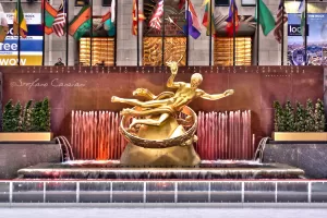 Fontana della Rockefeller Plaza Fontana della Rockefeller Plaza con scultura dorata e bandiere internazionali sullo sfondo