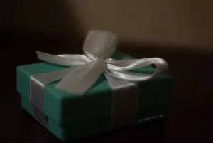 Scatola regalo di colore verde con un nastro bianco elegante