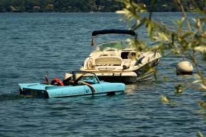 Due barche nel lago, una blu elettrico e un'altra bianca, immerse in un paesaggio sereno