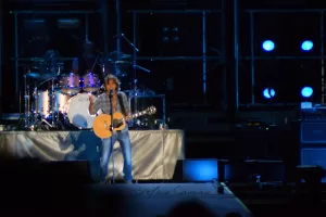 Luciano Ligabue – Concerto dal Vivo Luciano Ligabue - Un cantante con chitarra elettrica si esibisce su un palco illuminato durante un concerto