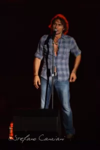 Luciano Ligabue – Concerto dal Vivo di Stefano Canziani Luciano Ligabue - Un uomo canta al microfono durante un'esibizione dal vivo sul palco