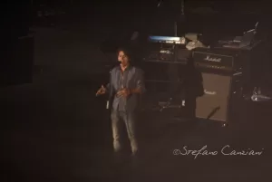 Luciano Ligabue – Esibizione dal vivo di un cantante Luciano Ligabue - Cantante su un palco con amplificatori sullo sfondo durante un'esibizione dal vivo