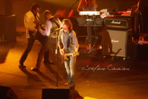 Luciano Ligabue - Performance dal Vivo Luciano Ligabue - Concerto dal vivo con musicisti sul palco, chitarre e amplificatori visibili