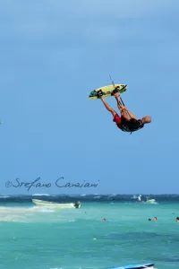 Adrenalina nel blu Kitesurfista che salta in alto sopra le onde in una giornata soleggiata al mare