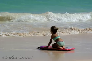 L’infanzia ha il suono delle onde Bambina che gioca su un galleggiante in riva al mare con onde dolci
