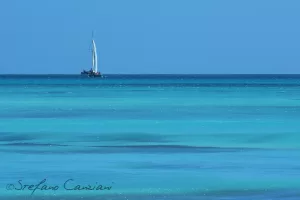 Navigazione tranquilla nel mare tropicale Barca a vela solitaria su acque turchesi in un mare tropicale