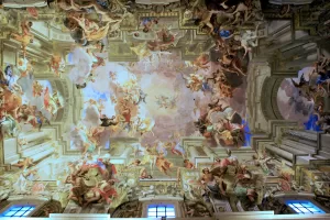 Affresco barocco con figure mitologiche e angeli sul soffitto di una chiesa