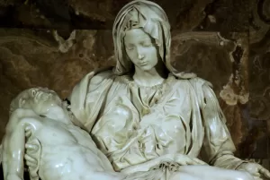 Il silenzio del dolore eterno Scultura in marmo della Pietà di Michelangelo con la Vergine Maria che sostiene il corpo di Gesù dopo la crocifissione, ambientata nella Basilica di San Pietro.