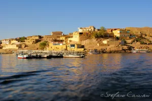 Villaggio sul lago con barche e case colorate ben illuminate dal sole