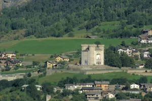 Castello di Aymavilles circondato da verdi colline e case tradizionali della Val d'Aosta