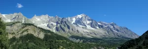 Panorama di montagne maestose con cime innevate e cielo blu in omaggio alla bellezza naturale