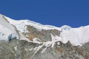 Cima montuosa con ghiacciaio Vista di una cima montuosa con ghiacciai e rocce sotto un cielo blu