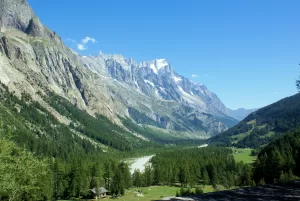 Panorama montano con vallata verde e fiume, circondato da cime imponenti