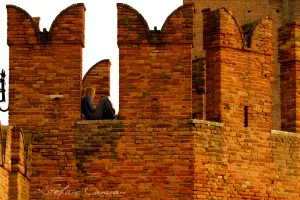 Un gioco di luci e spazi Ruderi di un castello medievale con una persona seduta sulle mura