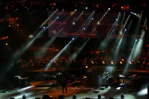 Luciano Ligabue - Concerto dal Vivo con Orchestra Luciano Ligabue - Palcoscenico con luci brillanti e orchestra durante un concerto dal vivo
