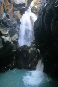 Cascata mozzafiato che scorre tra imponenti rocce in un ambiente naturale affascinante