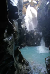 Una cascata che scorre attraverso rocce scure in un ambiente naturale mozzafiato