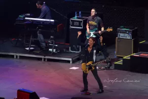 Luciano Ligabue - Concerto dal vivo Luciano Ligabue - Musicisti sul palco durante un concerto con chitarra, tastiera e batteria