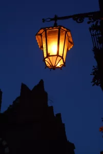Lampione caldo che illumina un cielo blu al crepuscolo in un ambiente urbano