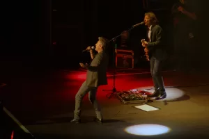 Luciano Ligabue - Performance dal Vivo Luciano Ligabue - Due musicisti sul palco durante un concerto con luci colorate