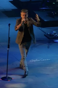 Luciano Ligabue - Concerto del cantante Luciano Ligabue - Cantante che si esibisce su un palco con microfono durante un concerto