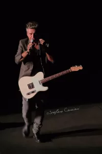 Luciano Ligabue - Concert Performance Luciano Ligabue - Musicista che si esibisce sul palco con una chitarra bianca sotto le luci