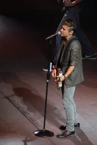 Luciano Ligabue - Esibizione dal Vivo Luciano Ligabue - Un cantante che si esibisce dal vivo con una chitarra su un palco