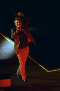 Luciano Ligabue - Eccitante Performance Musicale Luciano Ligabue - Cantante in performance su palco con luci bocca di lupo mentre interagisce con il pubblico