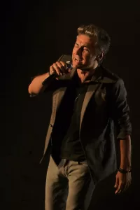 Luciano Ligabue - Performances Musicali Luciano Ligabue - Cantante in performance dal vivo mentre sostiene un microfono e canta con passione