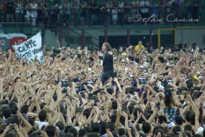Luciano Ligabue - Concerto affollato con un artista sul palco Luciano Ligabue - Un grande concerto affollato con il cantante sul palco e il pubblico esultante.