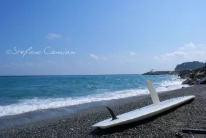 Spiaggia con surfista e mare azzurro in una giornata soleggiata