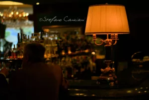 Una combinazione perfetta Lampada elegante illuminata in un bar raffinato con un cliente seduto al bancone