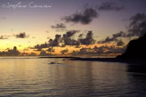 Tramonto sereno su una spiaggia con colori caldi e nuvole nel cielo