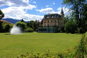 Villa storica immersa nel verde Villa storica circondata da un ampio giardino verde con fontana e montagne sullo sfondo